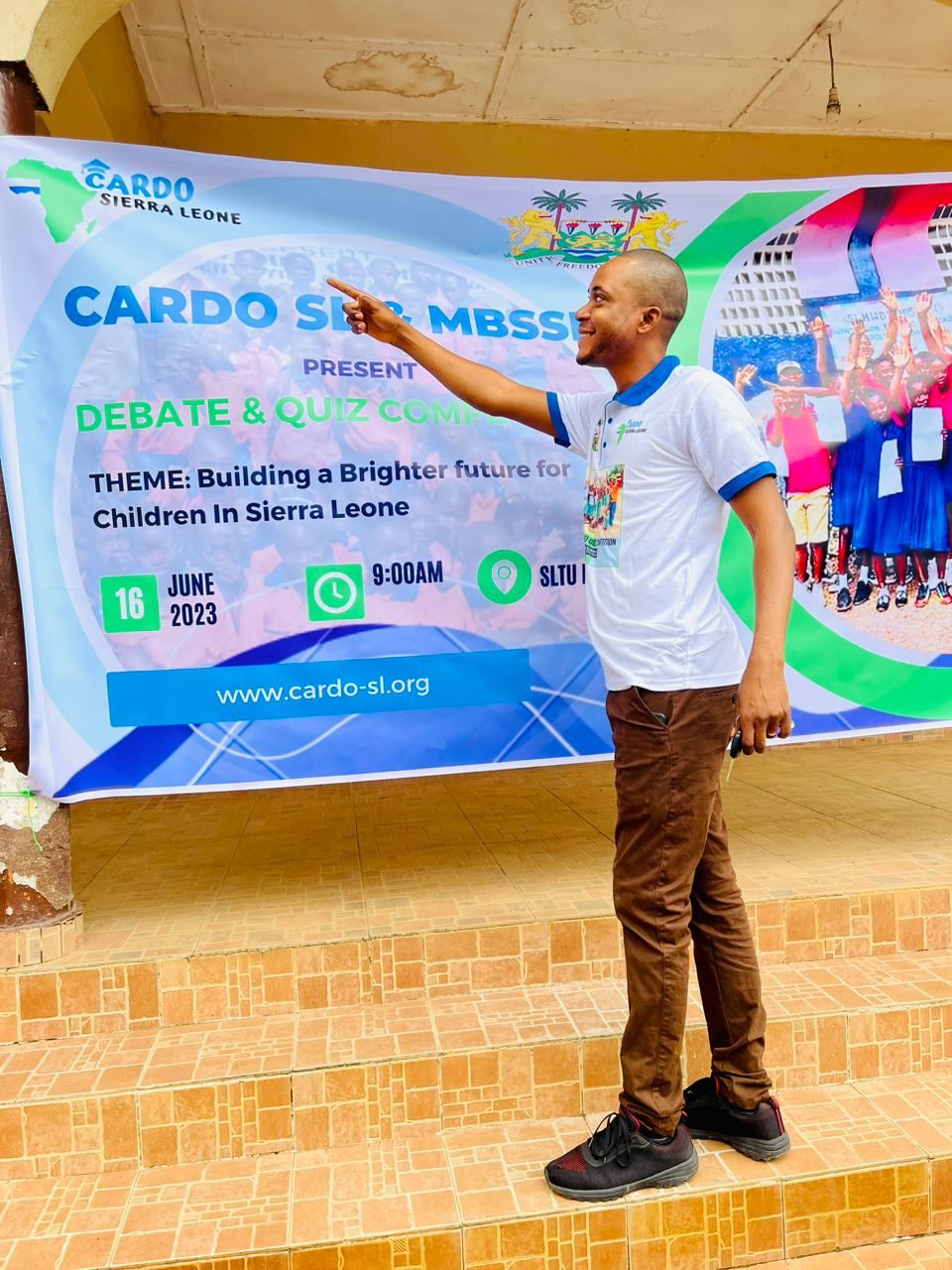 CARDO’s founder speaking in front of the Debate and Quiz Competition banner